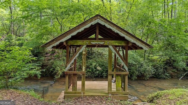 view of home's community featuring a wooden deck, a view of trees, and a gazebo