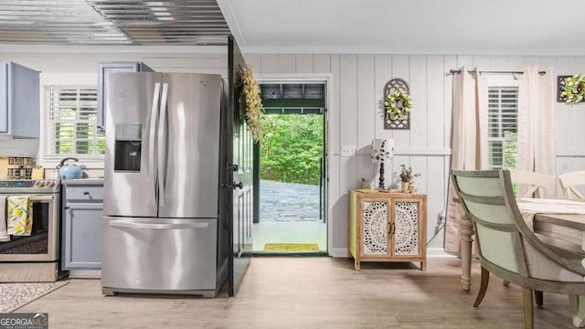 kitchen featuring crown molding, appliances with stainless steel finishes, gray cabinets, and light wood-style floors