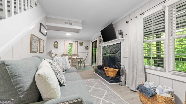 living room featuring visible vents, a fireplace, and wood finished floors