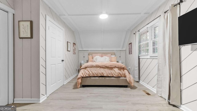 bedroom featuring vaulted ceiling, wood finished floors, visible vents, and baseboards