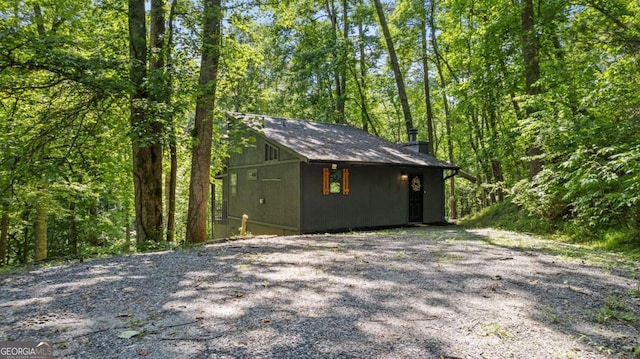 view of outdoor structure with an outbuilding and a forest view