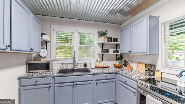 kitchen with open shelves, appliances with stainless steel finishes, gray cabinets, and a sink