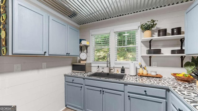 kitchen with open shelves, gray cabinets, and a sink