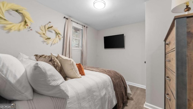 bedroom with baseboards and wood finished floors