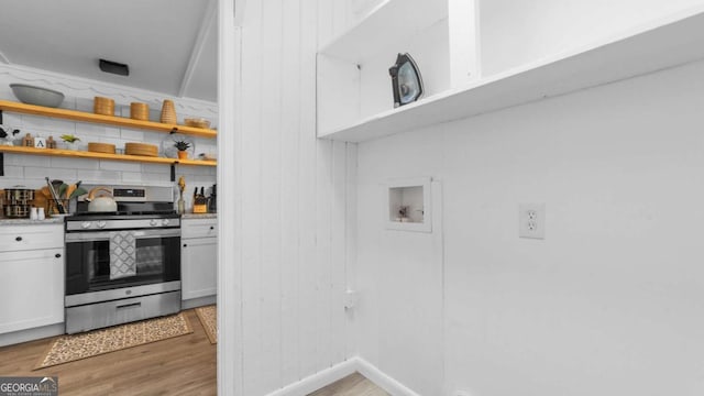 kitchen featuring stainless steel range oven, open shelves, decorative backsplash, and light wood finished floors