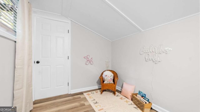 sitting room with vaulted ceiling, baseboards, and wood finished floors