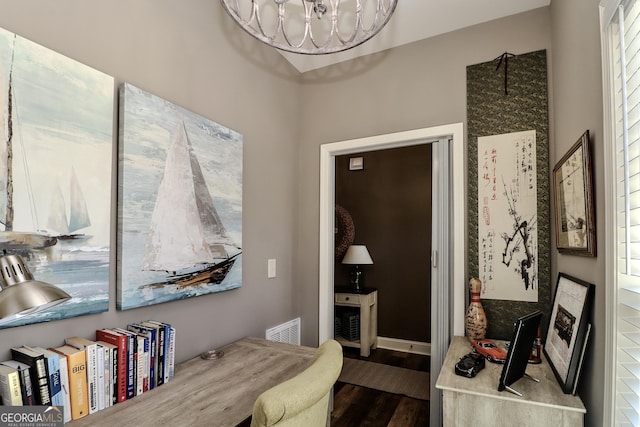 interior space with baseboards, a notable chandelier, visible vents, and wood finished floors