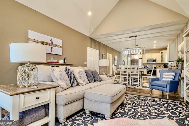 living room featuring vaulted ceiling, dark wood-type flooring, recessed lighting, and a notable chandelier