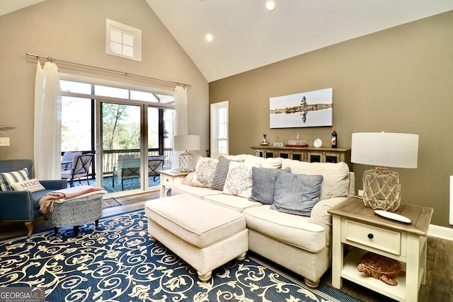 living room featuring high vaulted ceiling, wood finished floors, and baseboards