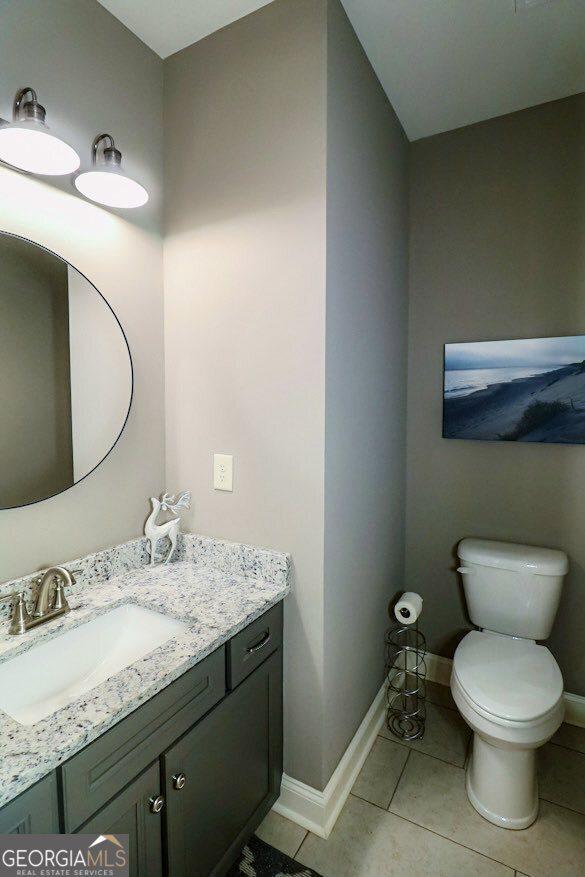 kitchen with stacked washing maching and dryer, recessed lighting, white cabinetry, and light tile patterned flooring