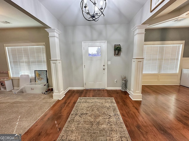 foyer entrance with an inviting chandelier, ornate columns, and wood finished floors