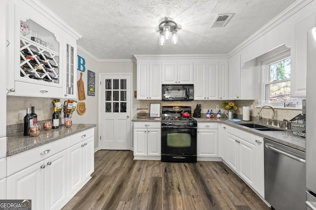 kitchen with visible vents, white cabinets, dark wood finished floors, black appliances, and a sink