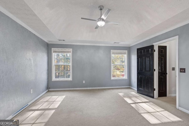 empty room with a wealth of natural light, a ceiling fan, and carpet flooring