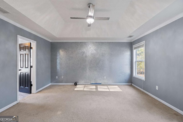 carpeted empty room featuring baseboards, ceiling fan, visible vents, and crown molding