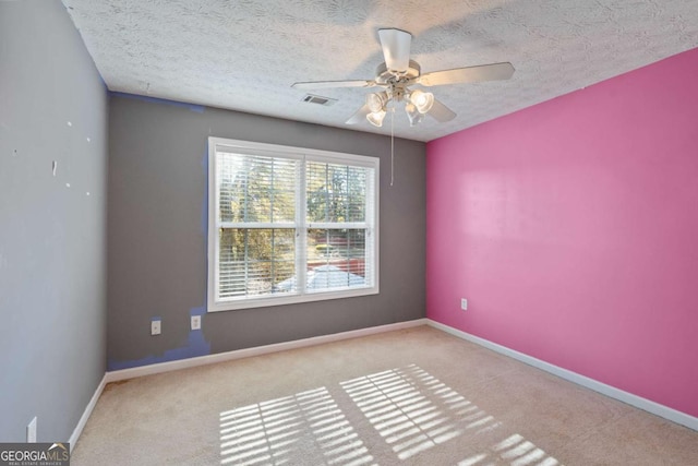 spare room featuring carpet, visible vents, and baseboards