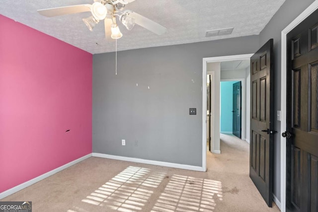 unfurnished bedroom with attic access, visible vents, light carpet, and baseboards