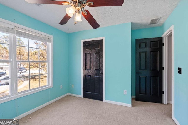 unfurnished bedroom with carpet, visible vents, and baseboards