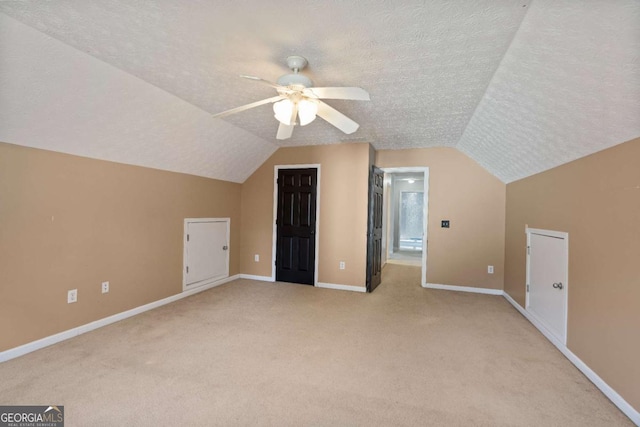 additional living space with a textured ceiling, carpet, and baseboards