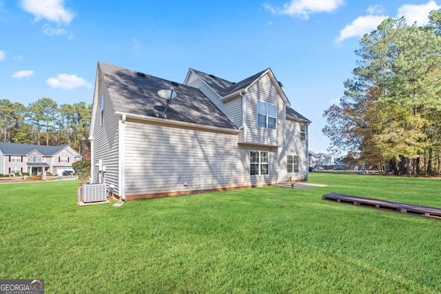 back of house featuring central AC and a lawn