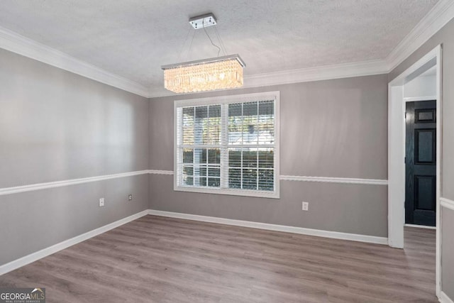 unfurnished dining area with ornamental molding, baseboards, and wood finished floors