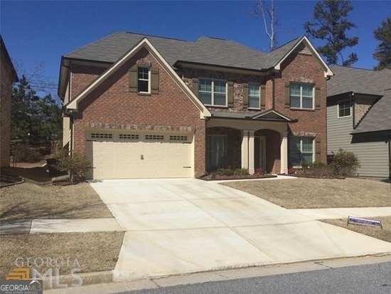 view of front facade with brick siding, concrete driveway, and a garage