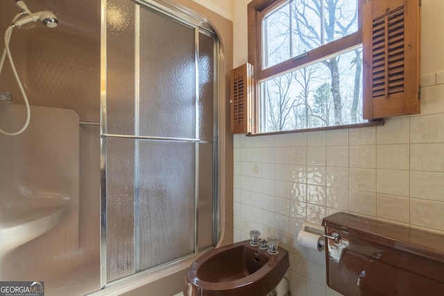 full bathroom featuring a shower stall, a bidet, and tile walls