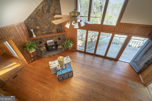 living area featuring wood walls, wood finished floors, and visible vents