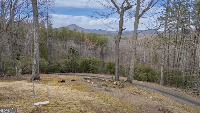 view of yard with a mountain view and a view of trees