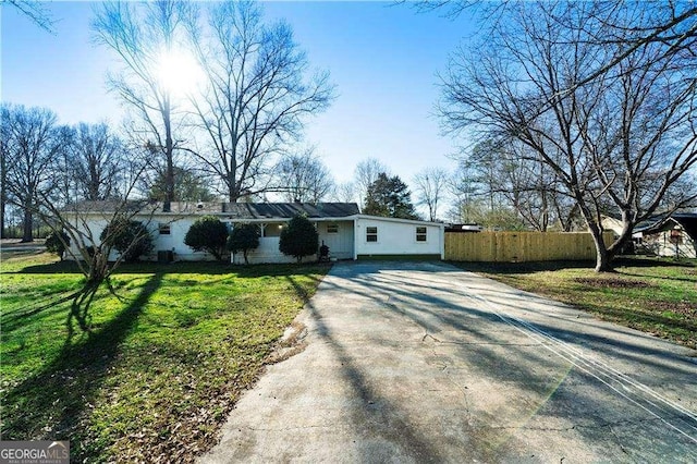 single story home featuring driveway, fence, and a front yard