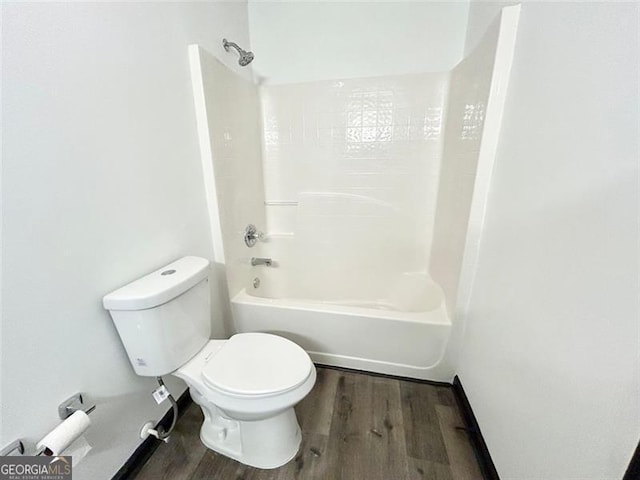 full bathroom featuring baseboards, shower / bath combination, toilet, and wood finished floors