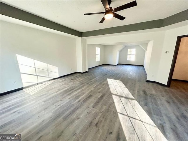 interior space with a ceiling fan, baseboards, and wood finished floors