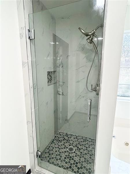 bathroom with a marble finish shower