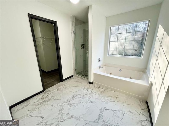 bathroom with baseboards, marble finish floor, a spacious closet, a whirlpool tub, and a stall shower