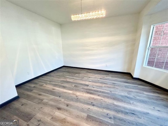 empty room featuring wood finished floors and baseboards