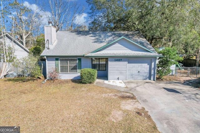 view of front of property featuring a garage, driveway, a chimney, fence, and a front yard