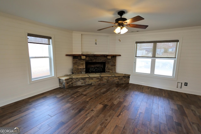 unfurnished living room with dark wood-style floors, a wealth of natural light, and ornamental molding