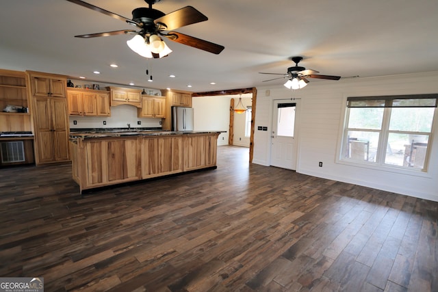 kitchen with open floor plan, a center island with sink, freestanding refrigerator, dark wood-style floors, and open shelves