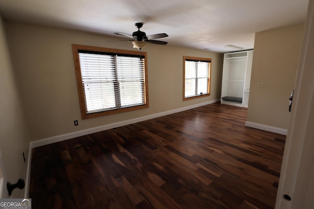 unfurnished bedroom featuring dark wood finished floors, baseboards, and ceiling fan