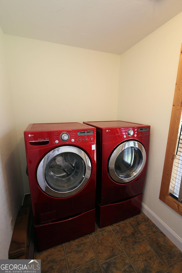 washroom featuring laundry area, baseboards, and separate washer and dryer