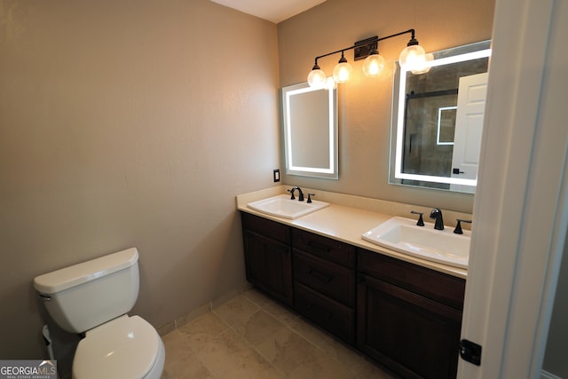 bathroom featuring a tile shower, double vanity, toilet, and a sink