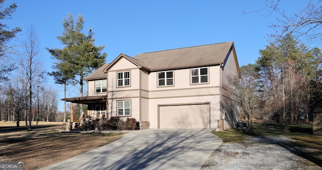 traditional-style house with covered porch, an attached garage, and concrete driveway