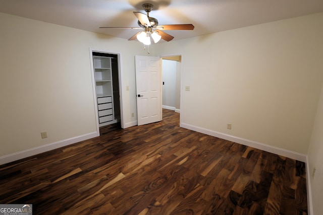 unfurnished bedroom featuring a ceiling fan, dark wood-type flooring, and baseboards