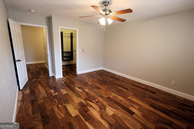 unfurnished bedroom with dark wood finished floors, a ceiling fan, and baseboards