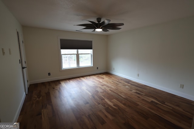 spare room with baseboards, wood finished floors, and a ceiling fan