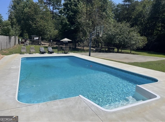 outdoor pool featuring a patio, fence, and basketball court