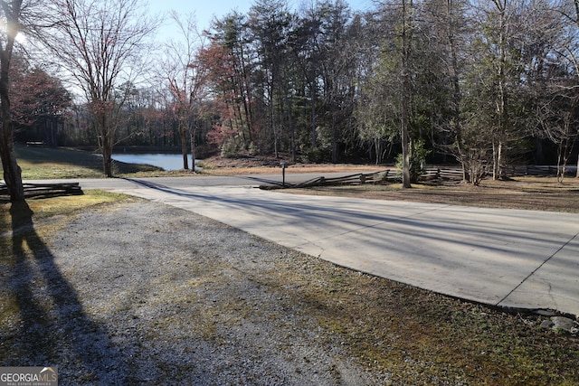 view of road featuring a water view and a view of trees