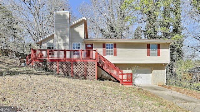 view of front of home featuring a garage, concrete driveway, a chimney, stairway, and a deck