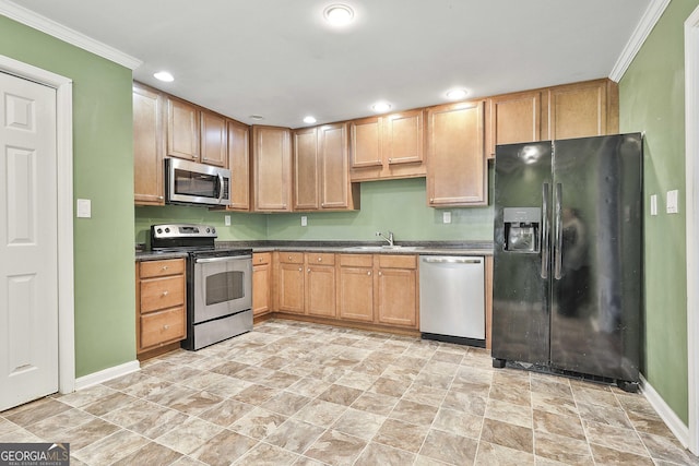 kitchen featuring dark countertops, ornamental molding, stainless steel appliances, a sink, and recessed lighting