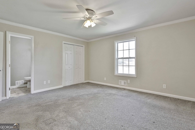 unfurnished bedroom with carpet floors, baseboards, visible vents, and crown molding