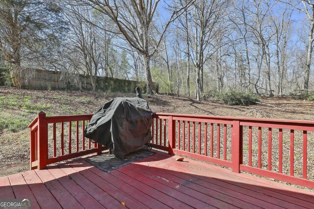 wooden deck with fence and area for grilling